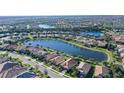 Aerial view of a residential area showcasing a lakefront property surrounded by beautiful landscaping and neighboring homes at 17026 Loudon Pl, Bradenton, FL 34202