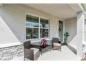 Relaxing front porch setting with comfortable seating and attractive stone accents at 17119 Harvest Moon Way, Bradenton, FL 34211