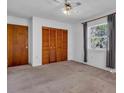 Bedroom with a ceiling fan, window with blinds, and a closet with louvered doors at 2004 49Th E Ave, Bradenton, FL 34203