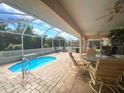 Relaxing screened-in lanai with pool, ceiling fans, and comfortable patio furniture at 26137 Dunedin Ct, Punta Gorda, FL 33983