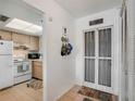 Inviting entryway with coat hooks leading into the kitchen with white appliances and natural wood cabinets at 2907 51St W Ave, Bradenton, FL 34205