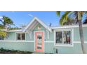 Charming beach home featuring a decorative door, well-lit entryway and tropical landscaping at 3007 Avenue E # A, Holmes Beach, FL 34217