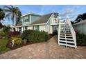 View of a two-story home with a wooden balcony accessible via exterior stairs at 3504 Estrada St, Sarasota, FL 34239
