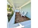 Inviting front porch with brick flooring and three Adirondack chairs offers a relaxing outdoor space at 3504 Estrada St, Sarasota, FL 34239