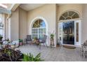 Cozy front porch with arched windows, tiled flooring, and seating area at 4705 Sweetmeadow Cir, Sarasota, FL 34238