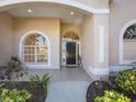 Welcoming front entrance featuring arched windows and a tiled porch at 4705 Sweetmeadow Cir, Sarasota, FL 34238