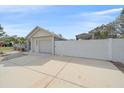 Wide driveway leading to a garage and a gated carport, enclosed by a white fence at 5002 Bunyan St, Sarasota, FL 34232