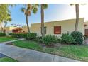 Condo exterior showcasing lush greenery, palm trees, and distinctive red window and balcony accents at 503 Spring Lakes Blvd # 503, Bradenton, FL 34210