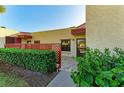 Inviting condo entrance with well-maintained landscaping, red latticework, and a welcoming 'HOME' sign at 503 Spring Lakes Blvd # 503, Bradenton, FL 34210