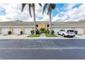 Building with garages, lush bushes and trees, and an inviting walkway at 6326 Grand Oak Cir # 203, Bradenton, FL 34203
