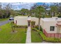 An aerial view of the villa with a well-manicured lawn, palm trees, and a walkway leading to the front door at 801 Spring Lakes Blvd # 801, Bradenton, FL 34210