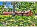A single story home with mature landscaping and expansive front yard and mature trees at 805 Mcarthur Ave, Sarasota, FL 34243