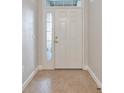 Inviting front entry features a white door with sidelight and transom window and neutral tile flooring at 9415 Discovery Ter # 101A, Bradenton, FL 34212