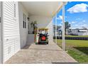 Attached carport featuring a golf cart and brick paved driveway leading to the main entrance at 115 E Saint Lucia Loop, Apollo Beach, FL 33572