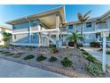 Two-story condo building featuring coastal blue siding, white accents, and lush landscaping at 1153 Edgewater Cir, Bradenton, FL 34209