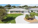 Aerial view of the property featuring a circular driveway, landscaping, and a charming, single story home at 1216 Yawl Way, Venice, FL 34285