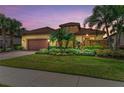 Inviting exterior view of a home with lush landscaping and a two-car garage at 13214 Treviso Dr, Bradenton, FL 34211