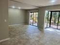 Bright living room with neutral paint and tile floors leading to sliding glass doors at 1697 Brookhouse Cir # 116, Sarasota, FL 34231