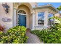 Elegant arched entry with blue front door, columns, and well manicured landscaping at 1720 85Th Nw Ct, Bradenton, FL 34209