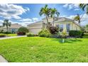 Charming single-story home featuring lush landscaping and a well-manicured lawn with blue sky at 1720 85Th Nw Ct, Bradenton, FL 34209