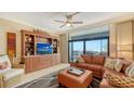 Bright living room with a wall unit and sliding glass doors to balcony overlooking the ocean at 1945 Gulf Of Mexico Dr # M2-516, Longboat Key, FL 34228