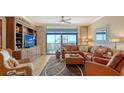 Bright living room with a wall unit and sliding glass doors to balcony at 1945 Gulf Of Mexico Dr # M2-516, Longboat Key, FL 34228