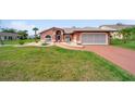 Charming single-story home with a well-manicured lawn, rock garden, and a two car garage at 215 Santarem Cir, Punta Gorda, FL 33983