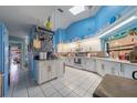 Bright kitchen with white cabinetry, tile floors, skylight, and modern appliances at 215 Santarem Cir, Punta Gorda, FL 33983