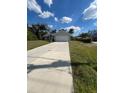 Single-story home with a long driveway, two car garage, and arched front entryway at 3722 S Cranberry Blvd, North Port, FL 34286