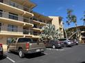 A tan condominium building features multiple levels of residences, complemented by convenient parking at 435 30Th W Ave # D303, Bradenton, FL 34205