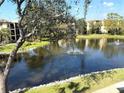 Scenic view of a serene pond with a fountain, surrounded by lush greenery and residential buildings at 435 30Th W Ave # D303, Bradenton, FL 34205