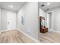 Bright entryway features wood-look flooring, hall tree, and neutral paint at 44325 Saddlewood Ct, Punta Gorda, FL 33982