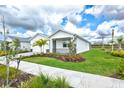 Charming single-story home with white exterior, well-manicured lawn, and lush landscaping at 44325 Saddlewood Ct, Punta Gorda, FL 33982