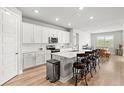 Modern kitchen boasts white cabinets, stainless appliances, and large center island at 44325 Saddlewood Ct, Punta Gorda, FL 33982