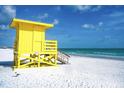 Picturesque beach scene with a vibrant yellow lifeguard tower on white sand under a sunny sky at 4710 Gleason Ave, Sarasota, FL 34242