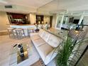 Open-concept living area features a sleek couch, mirrored wall, and breakfast bar leading to the kitchen at 500 N Osceola Ave # 203, Clearwater, FL 33755