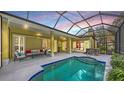 Screened-in pool area with comfortable seating, a hot tub, and sliding glass doors to the home's interior at 6114 Misty Oaks St, Sarasota, FL 34243