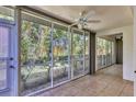 Screened lanai provides a serene outdoor space with a ceiling fan, tile flooring, and view of greenery at 6639 Pineview Ter # 6639, Bradenton, FL 34203