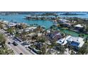 An aerial view showcases a luxury waterfront home with private boat dock, surrounded by mature trees at 732 Siesta Dr, Sarasota, FL 34242