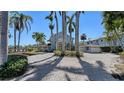 A luxurious home with a circular brick driveway lined with majestic palm trees and lush landscaping at 732 Siesta Dr, Sarasota, FL 34242