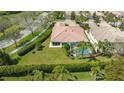 Overhead view of a screened-in pool, manicured yard, and a meticulously kept clay tile roof in a beautiful neighborhood at 7649 Quinto Dr, Sarasota, FL 34238