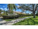 Beautiful property showcasing a meticulously maintained lawn, mature landscaping, and a welcoming facade at 7649 Quinto Dr, Sarasota, FL 34238