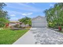 Charming single-Gathering home with a lush lawn, landscaping, a wide driveway, and a gray tile roof at 8956 Stone Harbour Loop, Bradenton, FL 34212