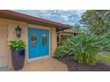 Close-up of the entry showing a bright blue door with oval glass inserts, adding a pop of color at 940 Siesta Key Pl, Sarasota, FL 34242