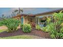 Beautiful exterior with professional landscaping, showcasing vibrant plants and a serene setting at 940 Siesta Key Pl, Sarasota, FL 34242