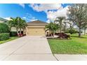 Charming home featuring a two-car garage, tropical landscaping, and well-maintained lawn at 12343 Halfmoon Lake Ter, Bradenton, FL 34211
