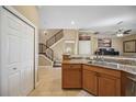 Open kitchen with granite countertops, wood cabinets, and views to the staircase and living room at 1308 3Rd Street E Cir, Palmetto, FL 34221