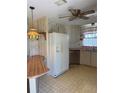 Cozy kitchen featuring white appliances, a hanging light fixture, and ample counter space at 197 Palm Harbor Dr, North Port, FL 34287