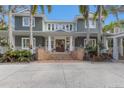 Charming home featuring a welcoming front entrance with brick steps and a meticulously landscaped yard with palm trees at 2828 Riverview Blvd, Bradenton, FL 34205