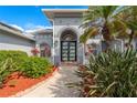 The entrance to the home with a walkway, lush greenery, and a contemporary door design at 292 Long Meadow Ln, Rotonda West, FL 33947